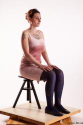 Sitting reference of whole body pink dress purple tights black shoes Nadine